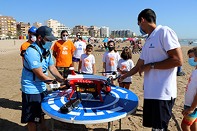 Alumnos y alumnas de la Escola d’Estiu asisten a una exhibición del dron de salvamento de la playa